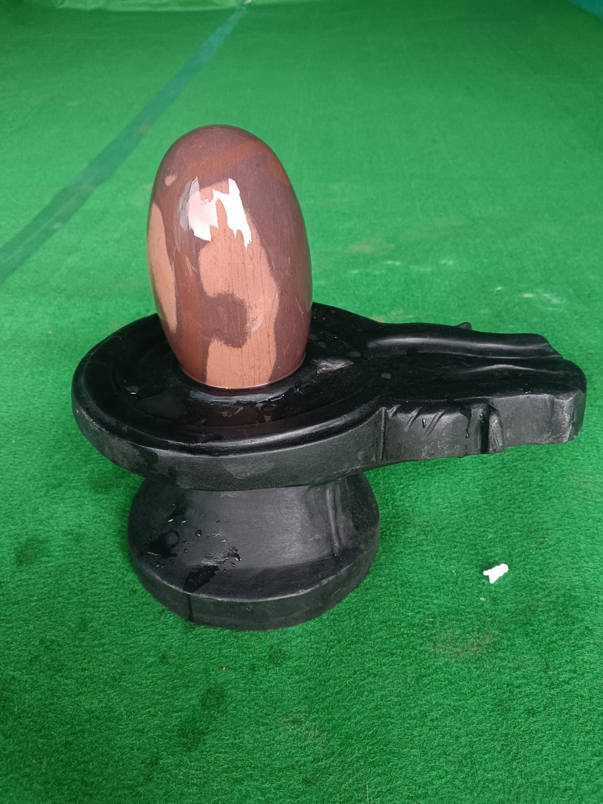 Small dark Narmadeshwar Shivling on a compact black yoni pitha, suitable for a home mandir
